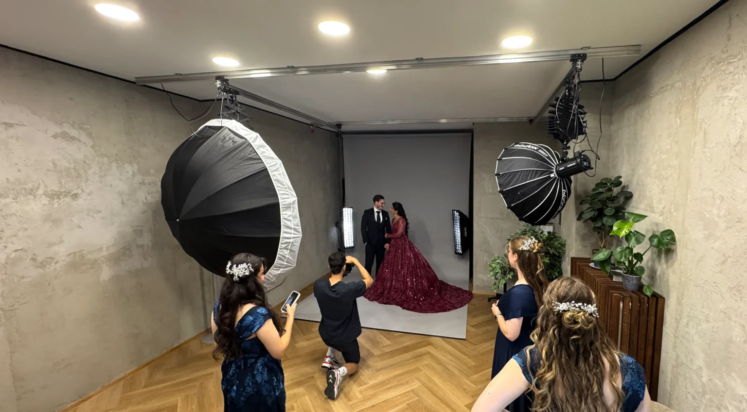 Brautpaar-Shooting im Mietstudio: Fotograf und Gäste vor dem grauen Hintergrund, Licht von den Deckenpantografen